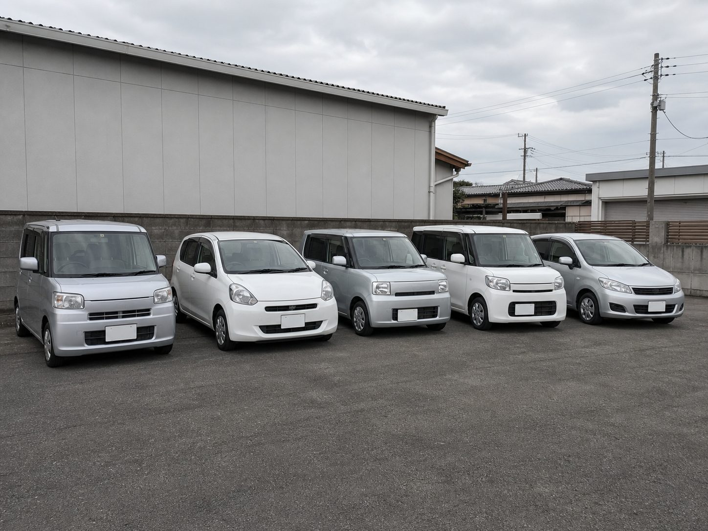 工場の駐車スペースに並ぶ代車の軽自動車とコンパクトカー